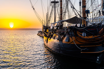 HMS Surprise ship, a tall modern replica of HMS Rose docked at Maritime Museum on the waterfront harbor bay in San Diego, Southern California at sunset.