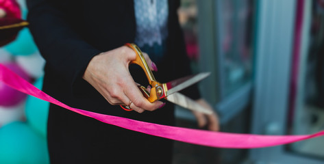 Process of cutting the red ribbon during the grand opening of the new shopping center mall...