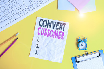 Text sign showing Convert Customer. Business photo text the percentage of visitors who take the desired action Copy space on notebook above yellow background with keyboard on table