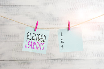 Text sign showing Blended Learning. Business photo showcasing combines traditional classroom lessons with online teaching Clothesline clothespin rectangle shaped paper reminder white wood desk