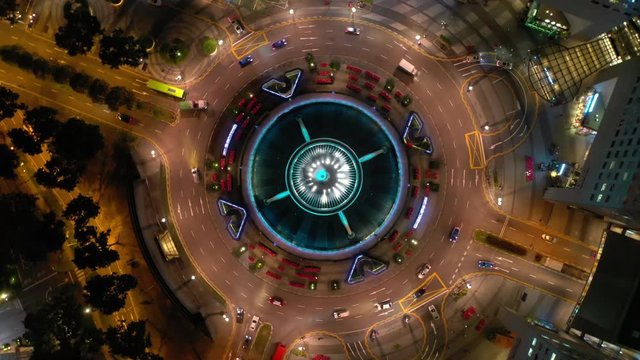night illumination flight over singapore city famous downtown traffic circle aerial topdown panorama 4k 