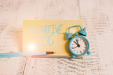 Handwriting text Innovative Ideas. Conceptual photo application of better solutions that meet new requirements Mini blue alarm clock stand tilted above buffer wire in front of notepaper
