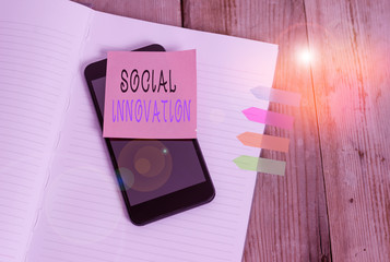 Word writing text Social Innovation. Business photo showcasing practices that aim to meet social needs in a better way Note book four arrow banners smartphone sticky note old wooden background