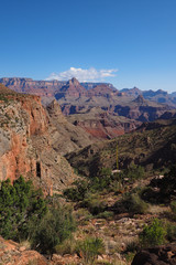 Early morning view from New Hance Trail in Grand Canyon National Park, Arizona under clear blue sky.