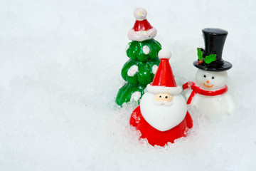 Santa Claus figure model and Christmas tree and Snowman  on the snow background  