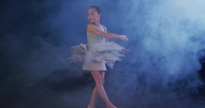 Ballerina doing pirouettes, child dancer spinning slow motion
