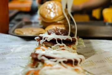 Cooking beef and chicken burgers on grill by night - Street food concept with mobile barbecue station open air in Sabah, Malaysia.