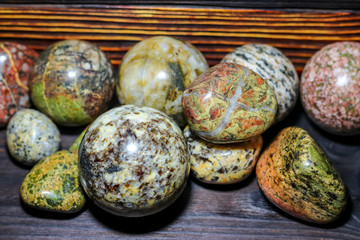 Collection of processed stones of different colors - magmatites - on a wooden background