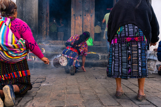 Tres mujeres mayas están echando  incienso en la entrada de la Iglesia de Santo Tomas Chichicastenango Guatemala.