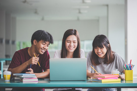 Group of friend or students smile happily with laptop on table on campus.