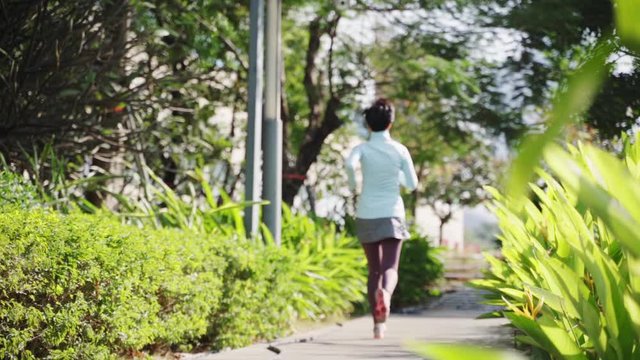 Asian beauty jogging in city park in morning slow motion