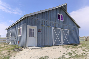 Fototapeta na wymiar Classic grey barn with loft and white trim