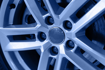 Wheel expensive car. Close-up chrome disc with low-profile rubber, selective focus. Toned in classic blue color. Trendy color of New Year 2020.
