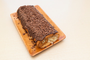 Delicious homemade rolled cake with chocolate icing and grated chocolate. Perpendicular view. Copy space. Horizontal shot.