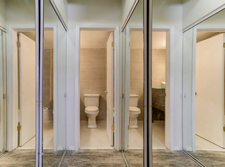 Many mirrors un this unique closet bathroom combination
