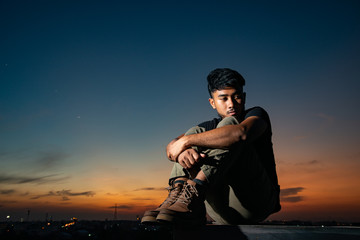 depress man on rooftop in twilight time