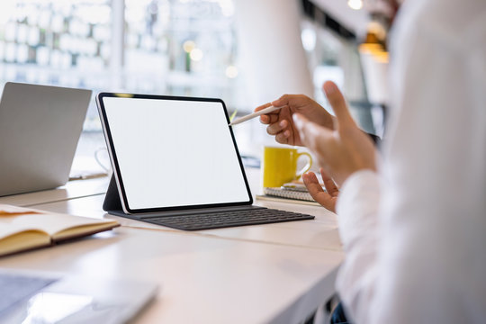 Mockup Blank White Desktop Screen Tablet With A Man And Woman Are Working In Background.