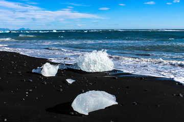 large pieces of iceburg on black sand beach in Iceland