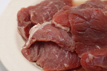 A plate of fresh raw meat on a white isolated background 