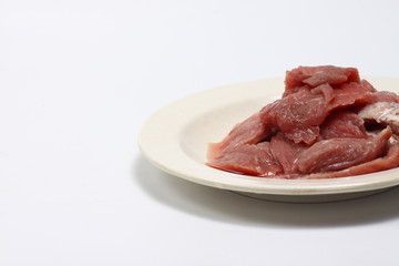 A plate of fresh raw meat on a white isolated background 