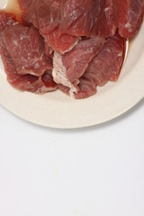 A plate of fresh raw meat on a white isolated background 