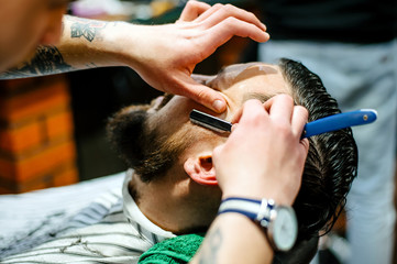 A man in a barbershop caring for his beard