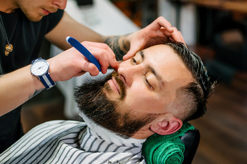 A man in a barbershop caring for his beard