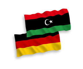 National vector fabric wave flags of Germany and Libya isolated on white background. 1 to 2 proportion.