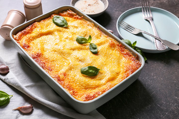 Tasty baked lasagna on dark background
