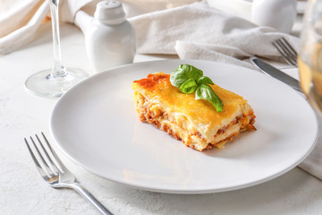 Plate with tasty baked lasagna on table