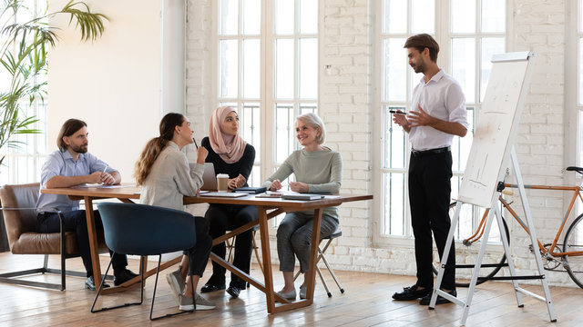 Happy teammates listening to trainer at workshop.