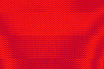 Deep saturated red background from a textile material with pattern, closeup. Structure of venetian red colored fabric with punching texture. Perforated cloth backdrop.