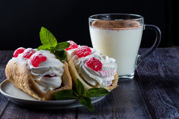 Air cake with raspberries on a saucer. Kefir with cinnamon, fermented drink. wood background