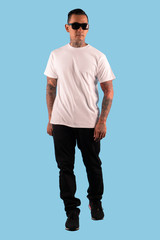 Fototapeta na wymiar Sixpack man tattooed wearing white t shirt isolated on plain background.