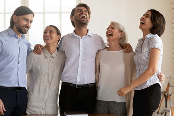 Portrait of happy laughing mixed race young and mature colleagues.