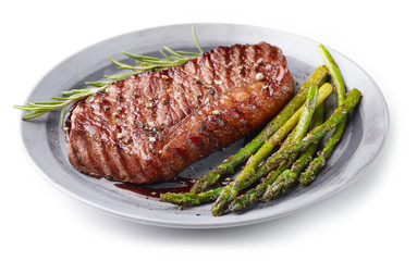 Cooked Beef steak on grey plate with asparagus and rosemary on white background