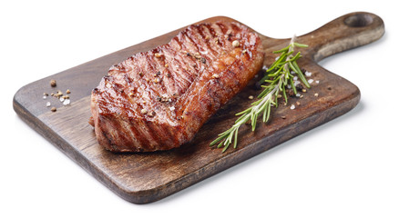 Grilled beef steak with rosemary on wooden board isolated on white background