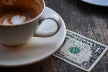 Money tip service, Coffee cup on wooden table.