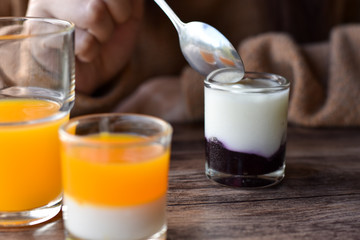Blueberry flavored yogurt in glass shot on wooden table.