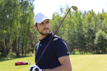 Man playing golf on beautiful sunny green golf course.