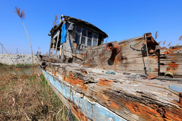 The broken wooden boat is on land