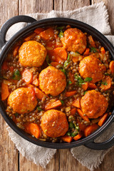 Steamed meatballs turkey with lentils and vegetables close-up in a pan. Vertical top view