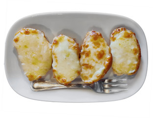 Bruschetta, a starter dish of Italy food, consisting of grilled bread rubbed with garlic and topped with olive oil, salt and cheese. serving on white plate and a fork. isolated on white