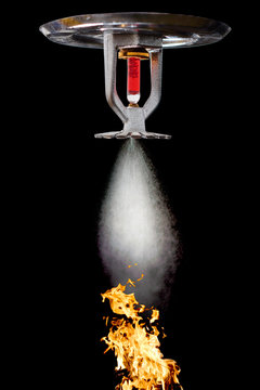 Fire Sprinkler spraying. Fire and water on background.