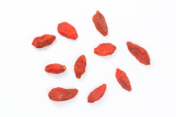 Spread out goji berries on a white background.