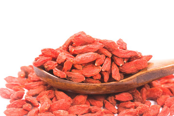 Wooden spoon scoop of goji berries on a white background.