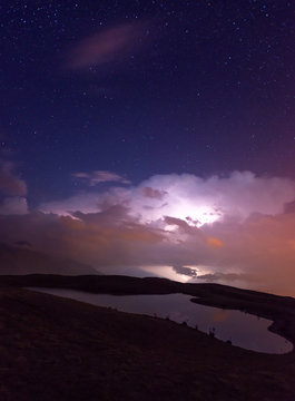 Night storm over mountain lake