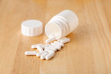 Fototapeta na wymiar Set of white pills are by the medicine bottle