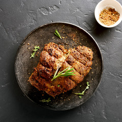 Barbecue meat. Grilled beef on plate over black stone background. Top view, flat lay