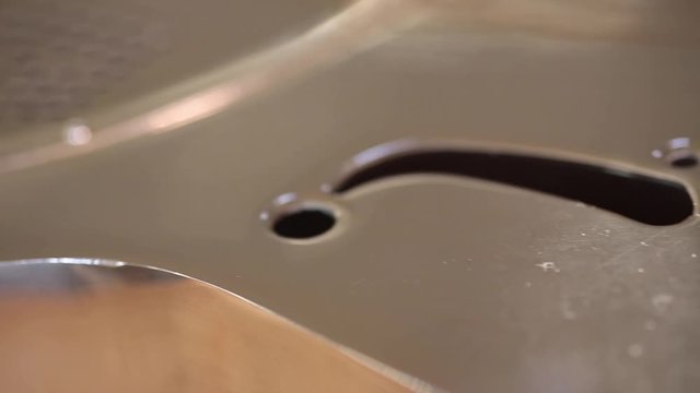 A resonator/national-steel guitar lying on a table in the sunlight. Camera rolls along the back length on a slider.